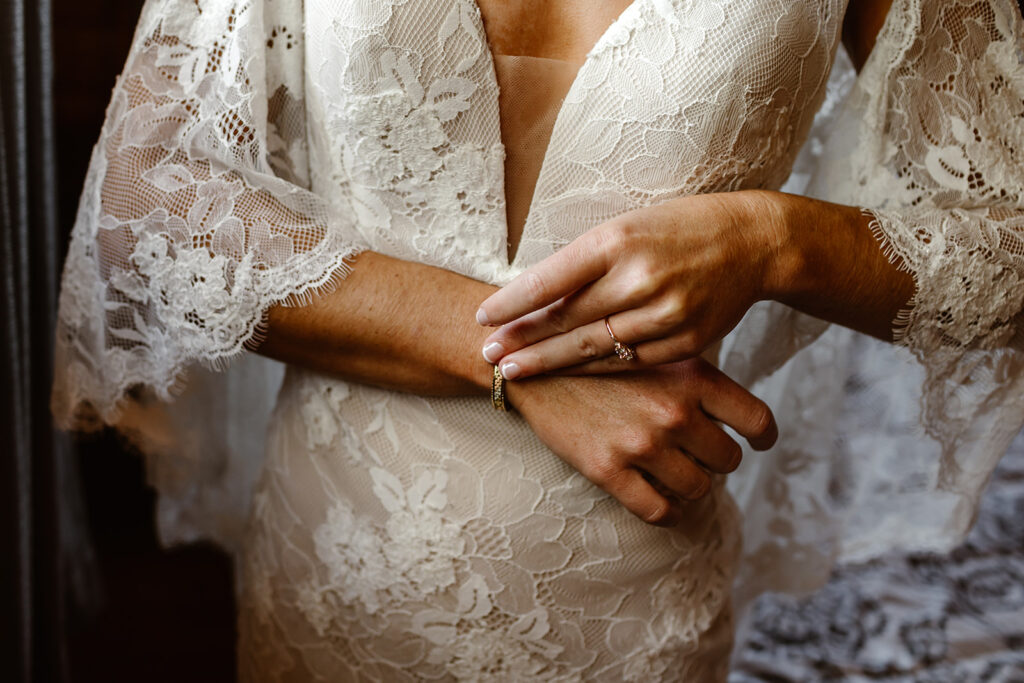 the bride getting ready in her lace wedding dress with sleeves