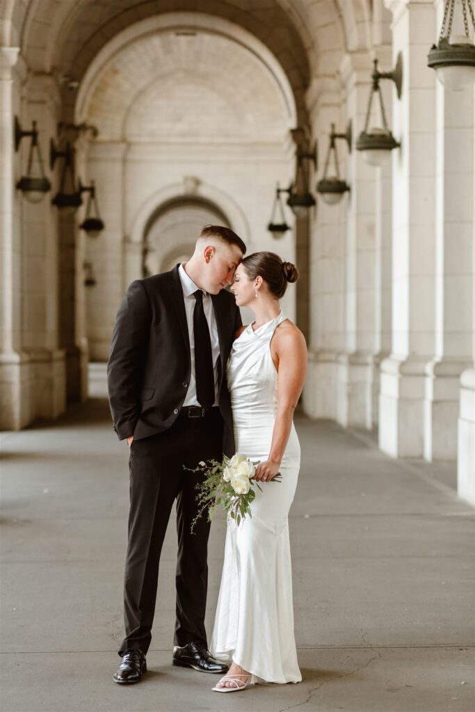 the wedding couple standing together outside of the Union Station for elopement photos