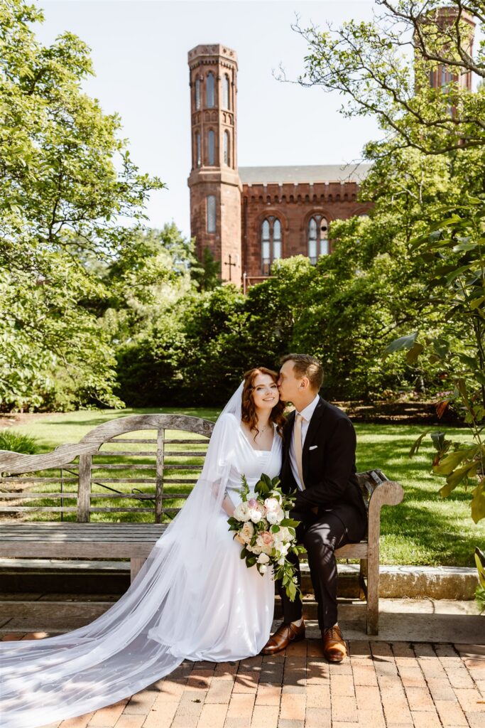 bride and groom sitting on a bench at enid a haupt garden at the smithsonian castle