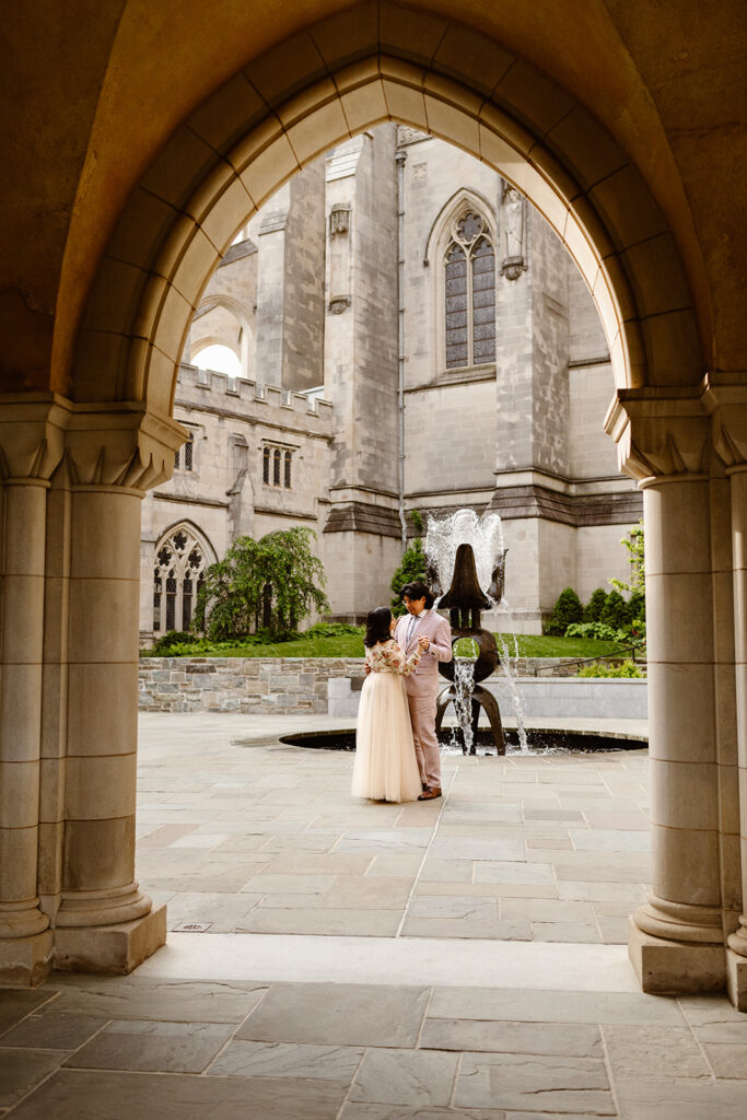 wedding couple dancing together in the courtyard at the National Cathedral