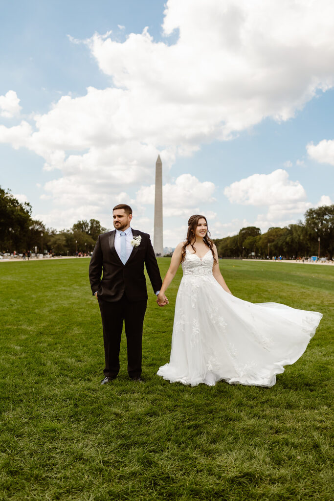 the wedding couple posing as the walk along the National Mall during their DC elopement