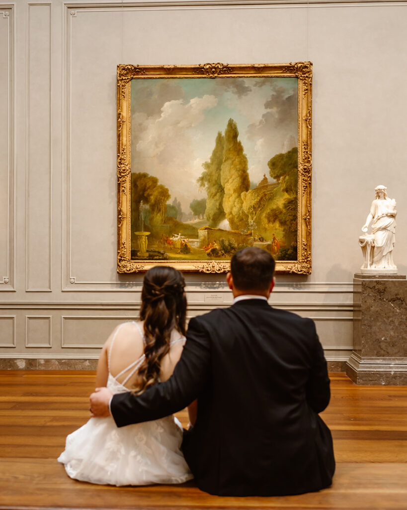 the wedding couple sitting down at the National Gallery of Art to enjoy their elopement