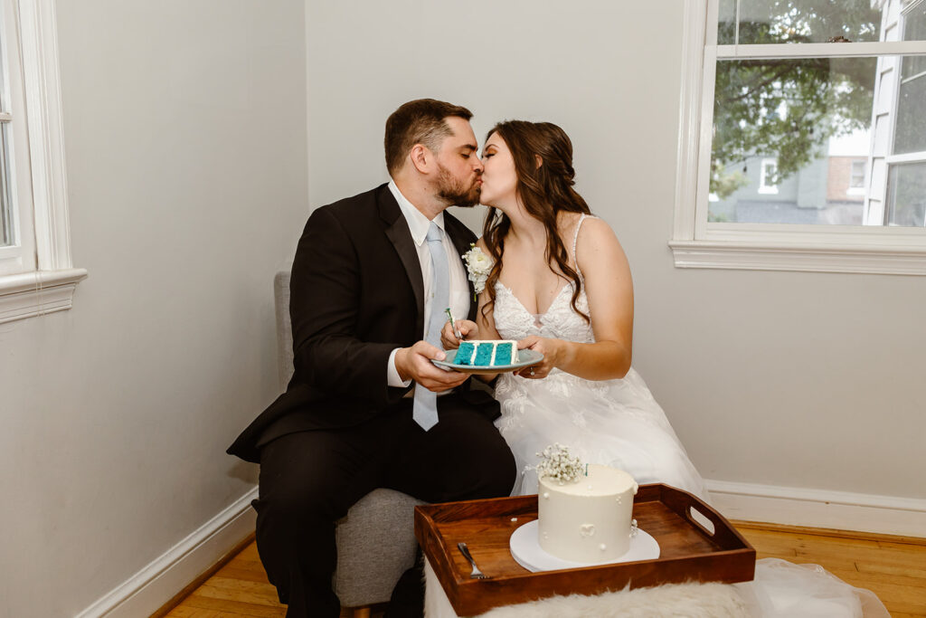 the wedding couple kissing after their gender reveal wedding cake