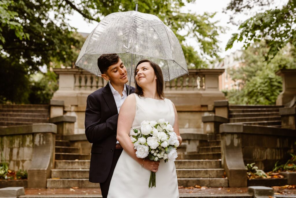 elopement couple under a clear umbrella during their dc elopement at the spanish steps