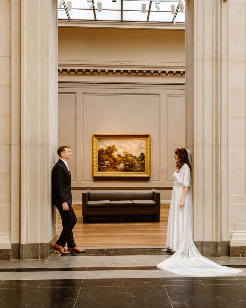 sweet elopement couple in front of a painting during their elopement at the national gallery of art in dc