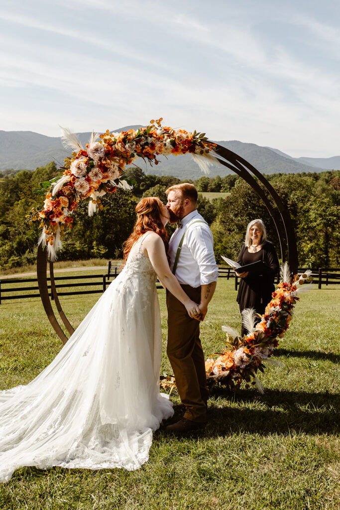 the wedding couple kissing during their wedding ceremony for their Virginia Elopement