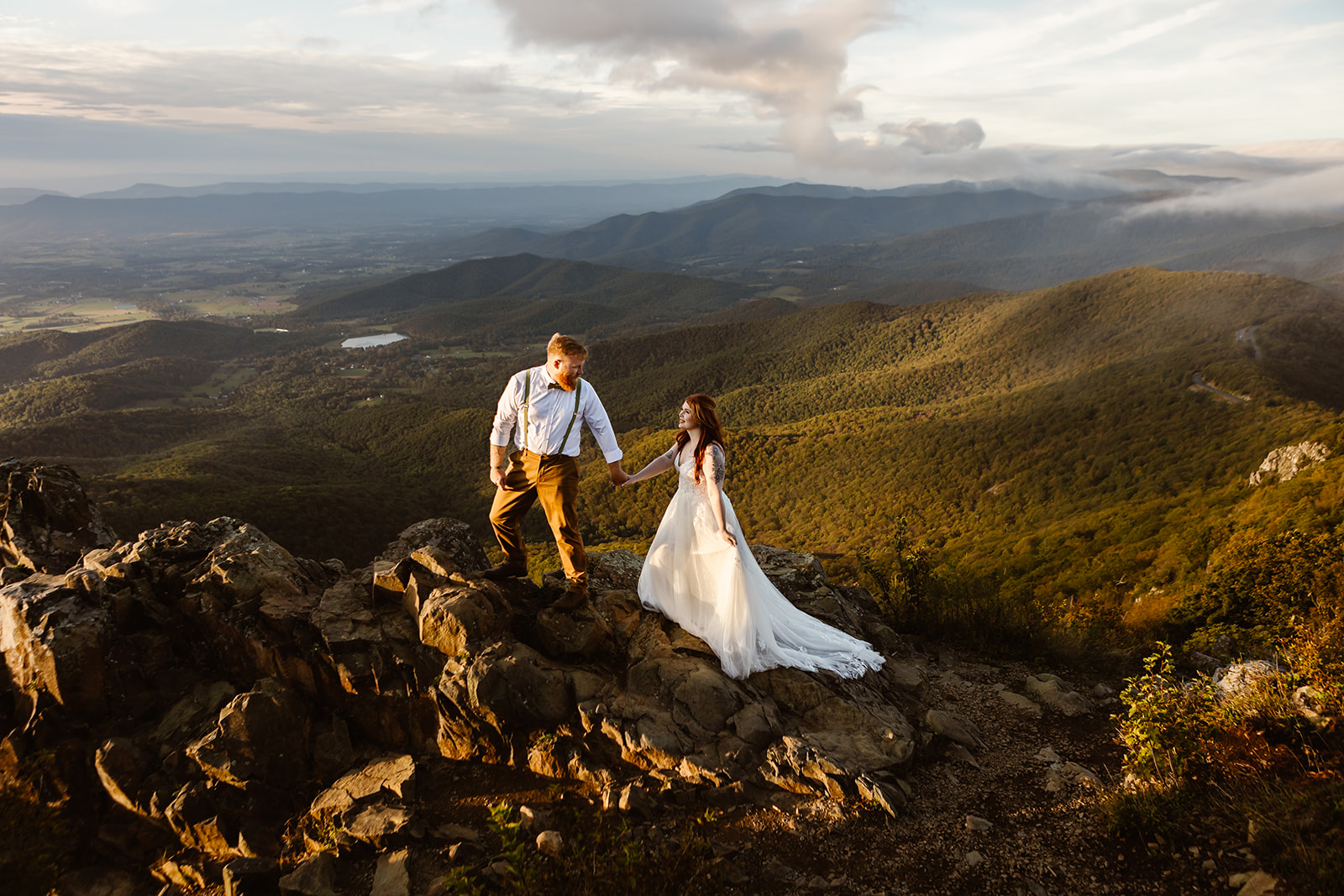 the wedding couple walking on the peaks of Shenandoah National Park