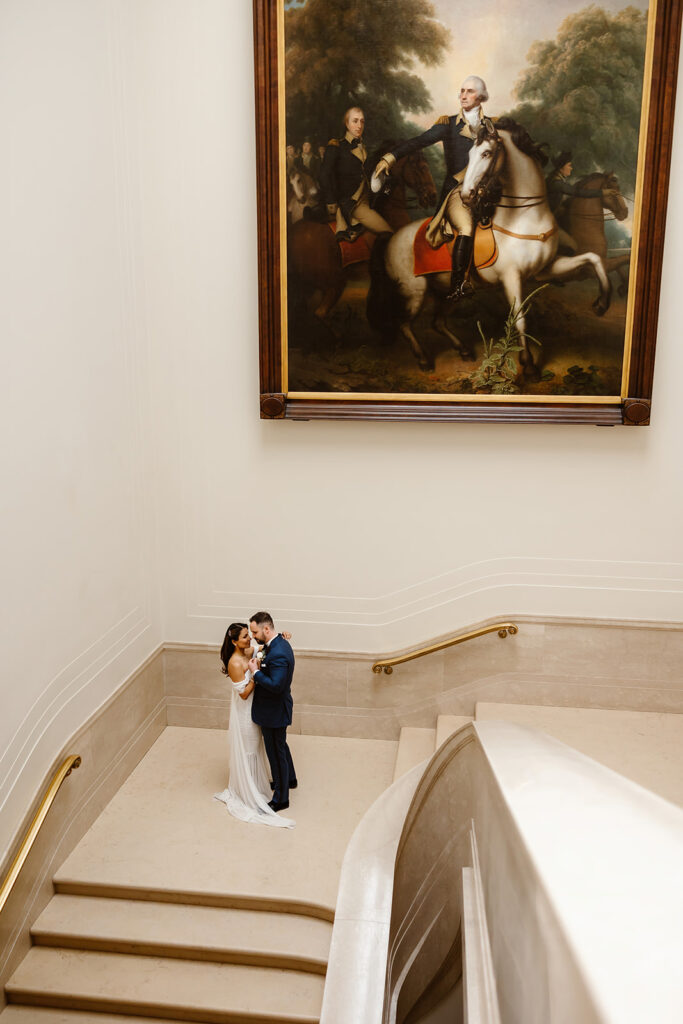 the wedding couple at the staircase of the art gallery 