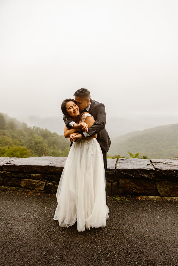 rainy elopement photos hugging and dancing in the rain at Shenandoah National Park