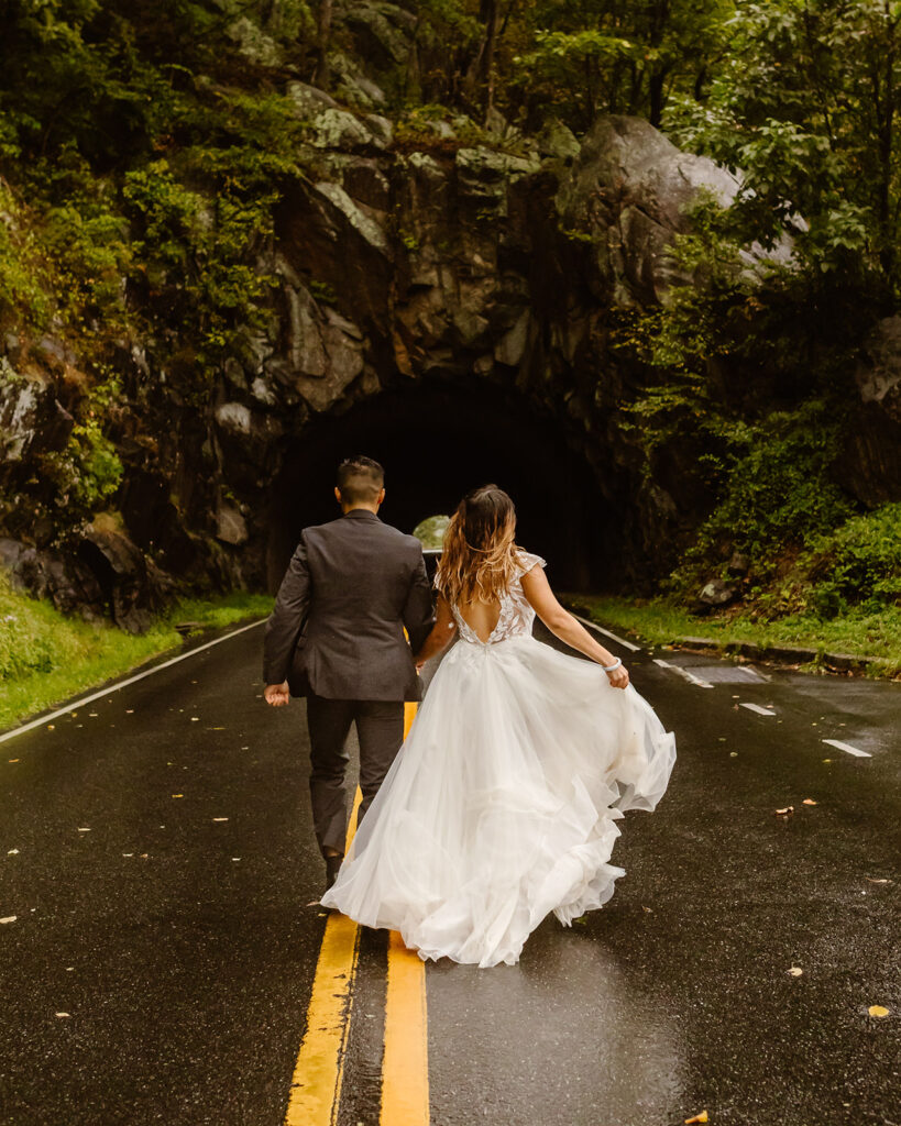 the bride and groom running through the rain together during their adventure elopement