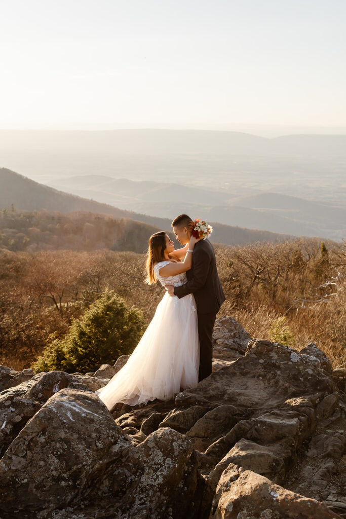 the wedding couple leaning in to kiss during sunset at Shenandoah National Park