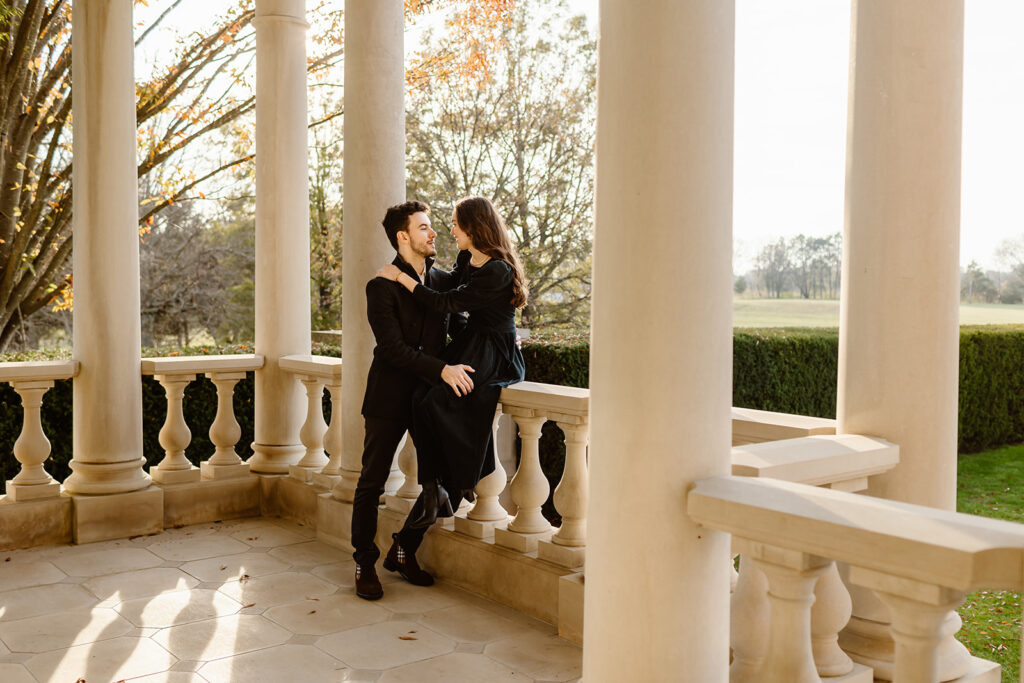 the engaged couple sitting on the balcony of the garden for engagement photos