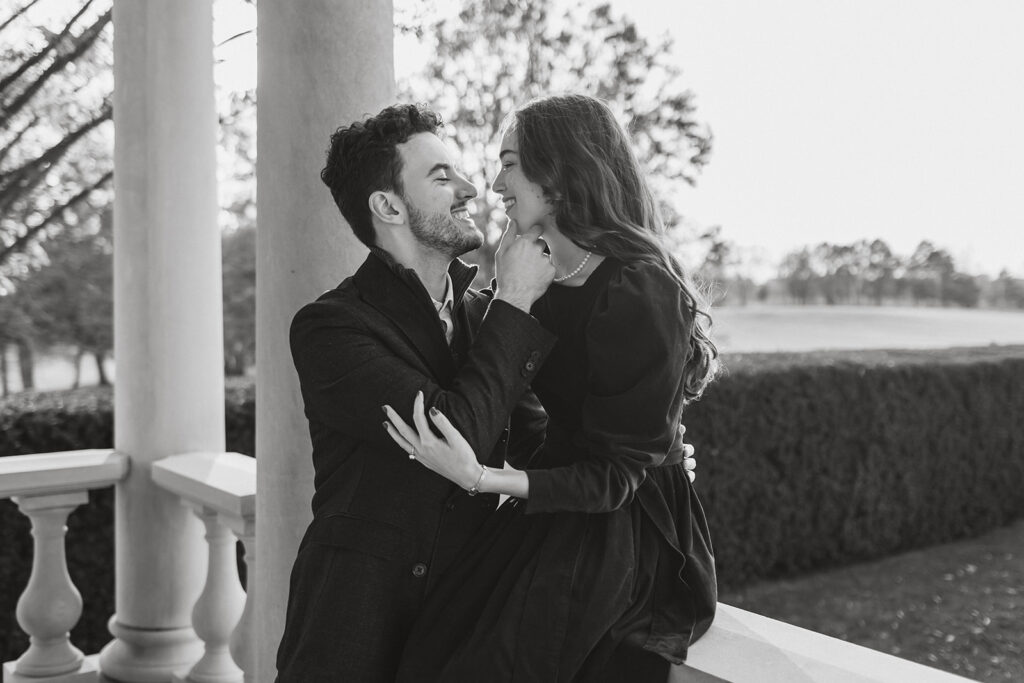 the engaged couple leaning in for a kiss at the Great Marsh Estate after their surprise proposal