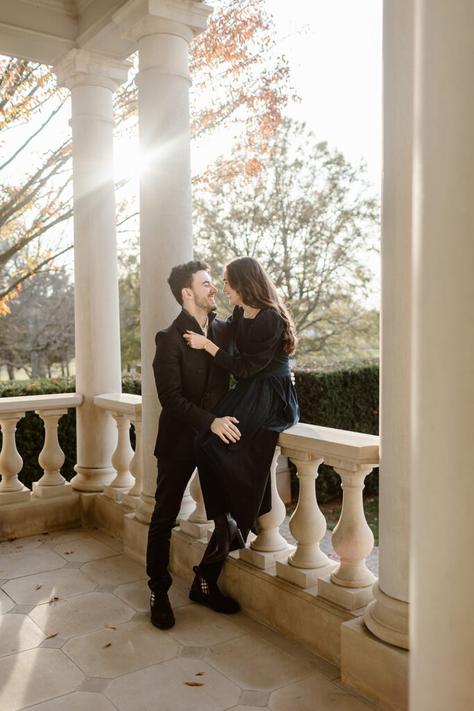 the engaged couple sitting on the balcony at the Great Marsh Estate for Golden Hour engagement photos