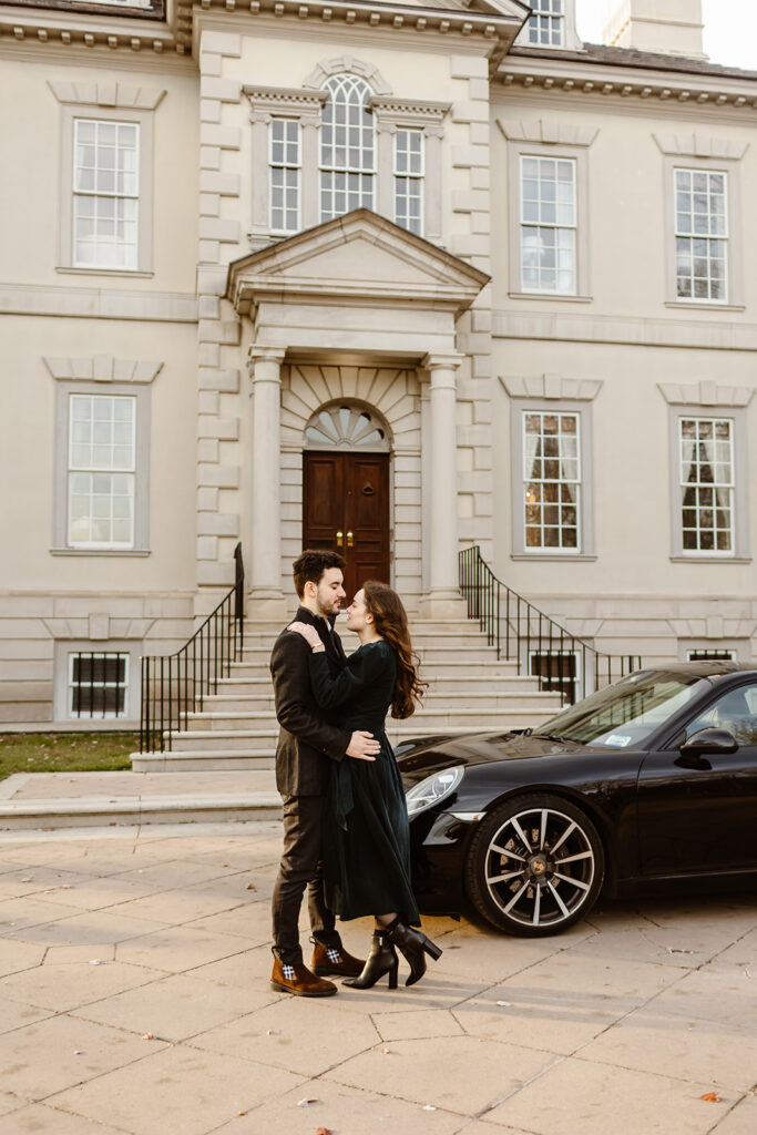 the engaged couple taking engagement photos with their car