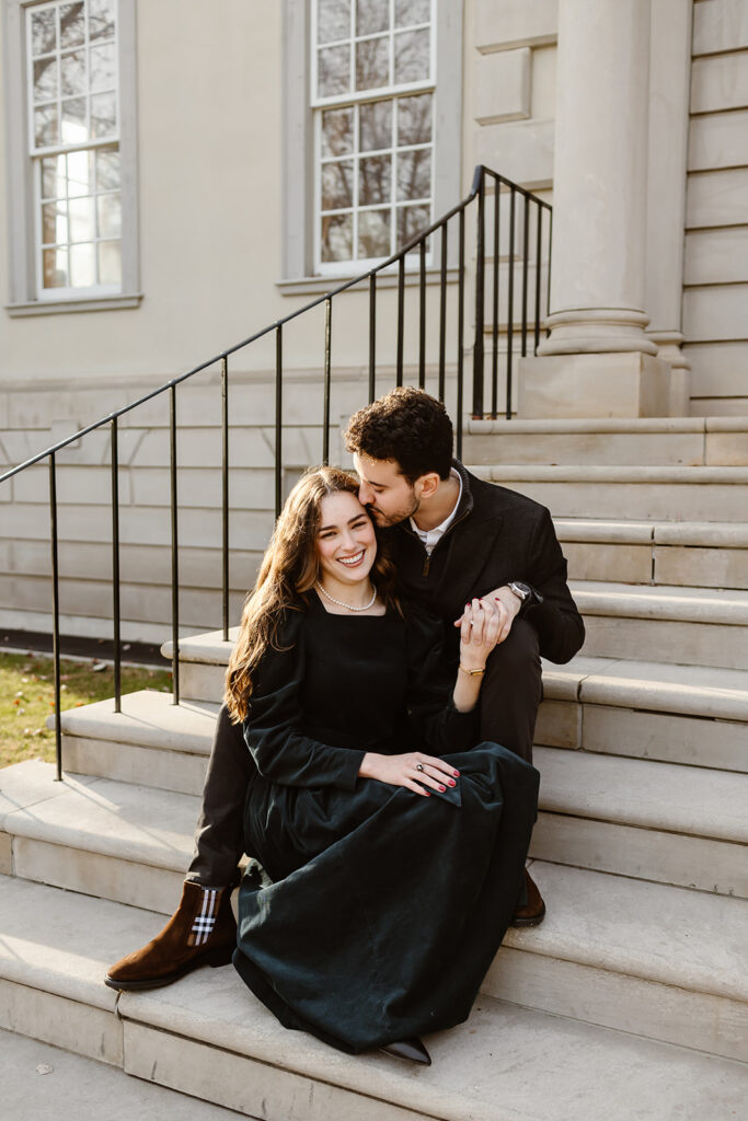 the engaged couple sitting on the stairs of the Great Marsh Estate