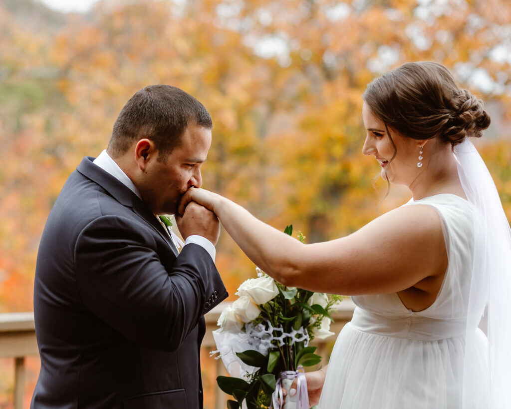 the groom kissing the bride's hand after their first look