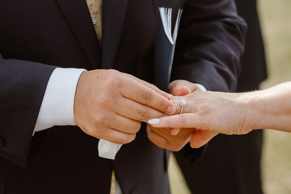 the groom placing the wedding ring on the bride's hand