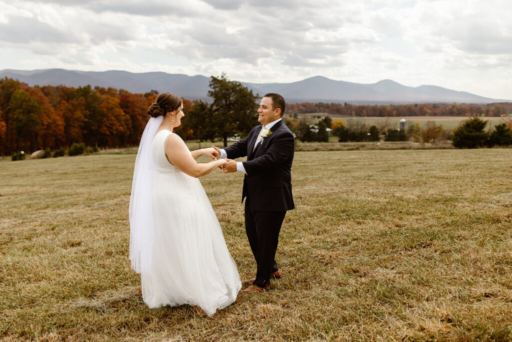 the wedding couple dancing together in a field