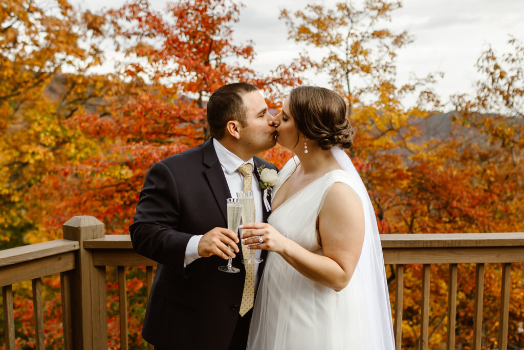 the wedding couple kissing with their champagne