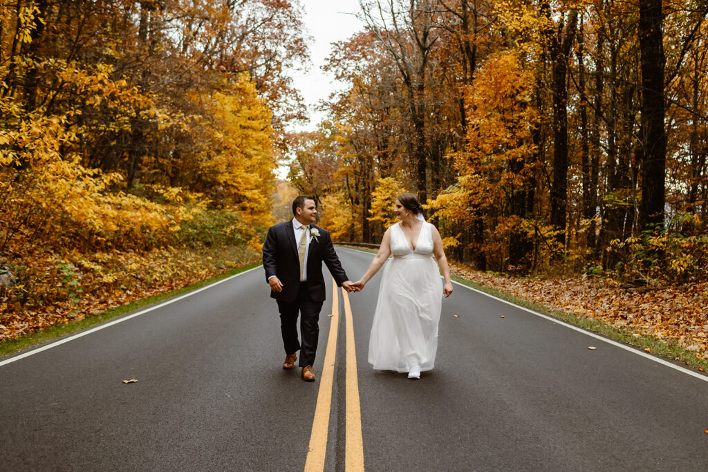 the wedding couple walking along the road together at Shenandoah National Park