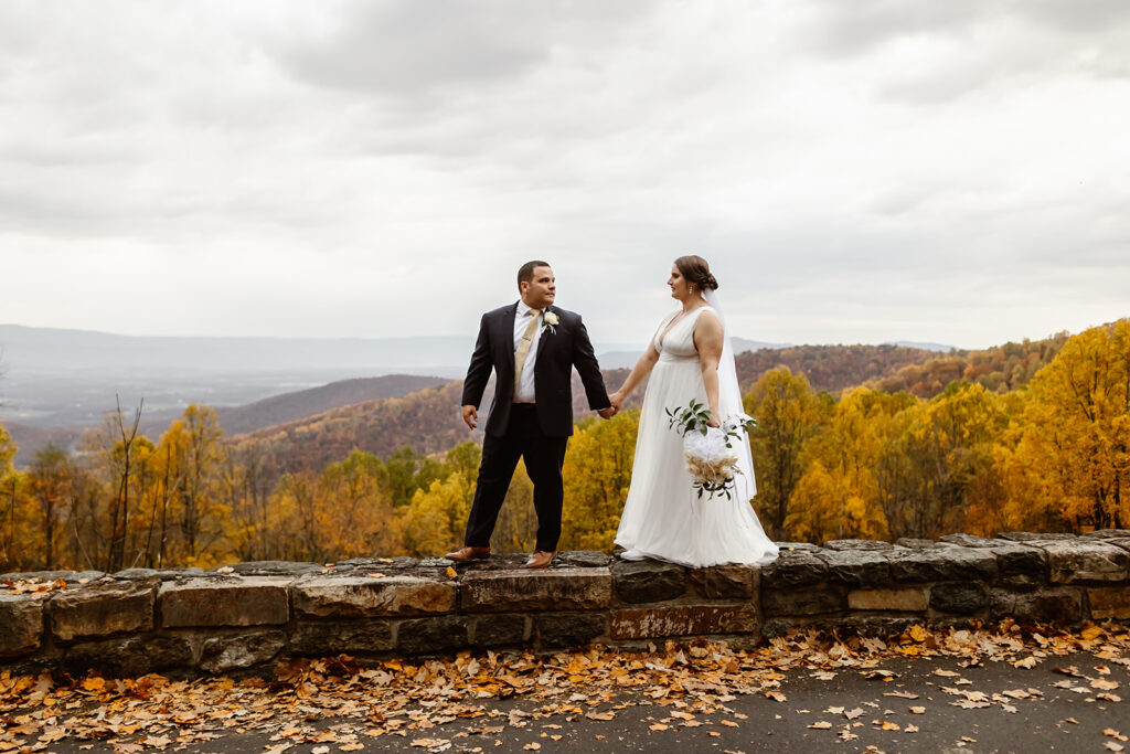 the wedding couple holding hands as they walk at Shenandoah National Park