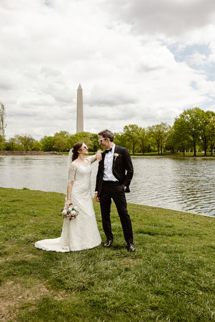 the bride and groom posing with their sunglasses near the Washington Monument