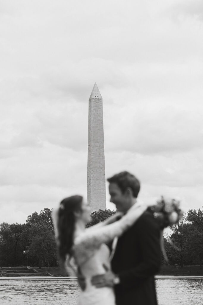 the wedding couple and the Washington Monument in black and white