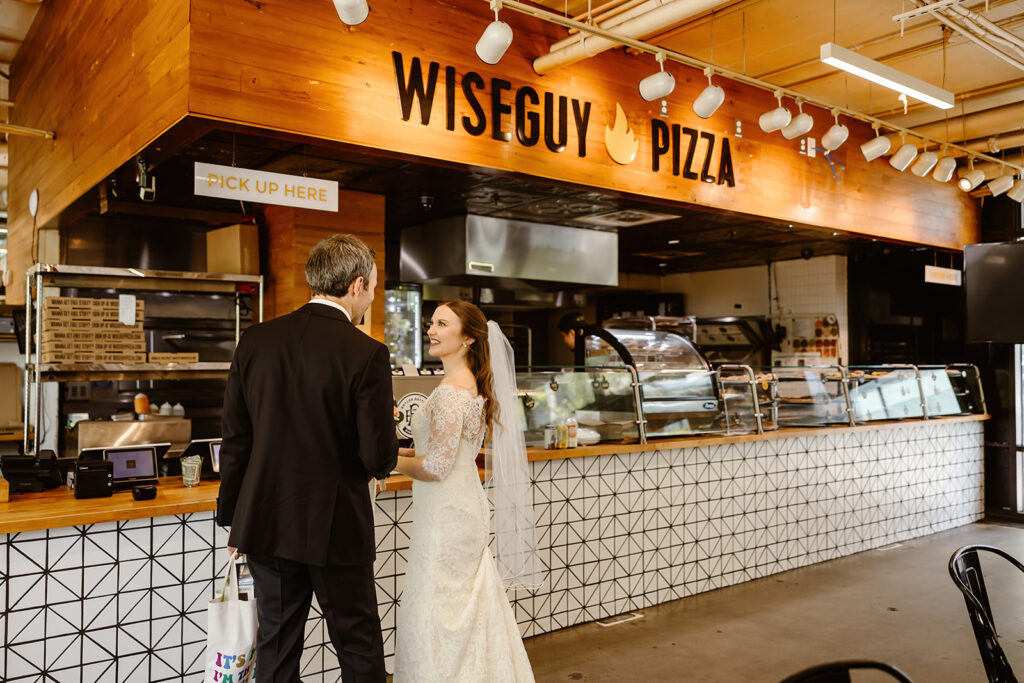 the bride and groom celebrating their DC elopement with pizza