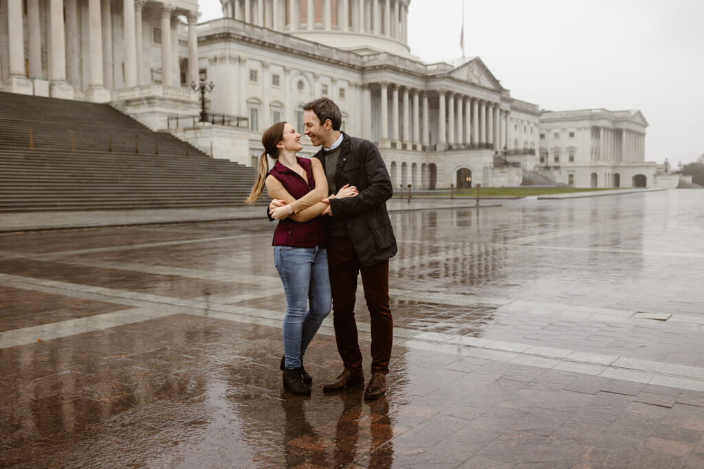 the engaged couple taking rainy engagement photos near the Capitol in Washington DC