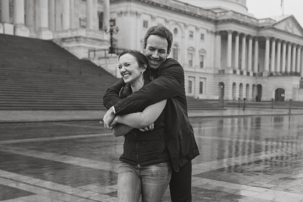 the engagement couple hugging in the rain during their Washington DC engagement photos at the Capitol 