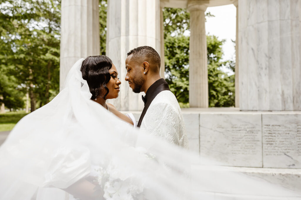 the wedding couple with the veil blowing in the wind