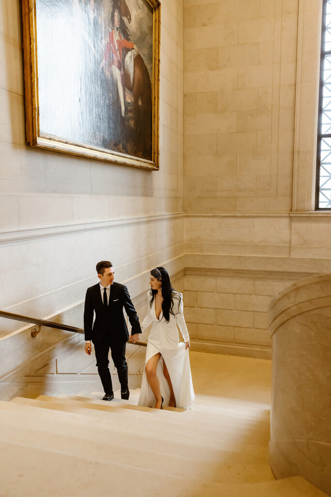 the wedding couple walking up the stairs at the National Gallery of Art