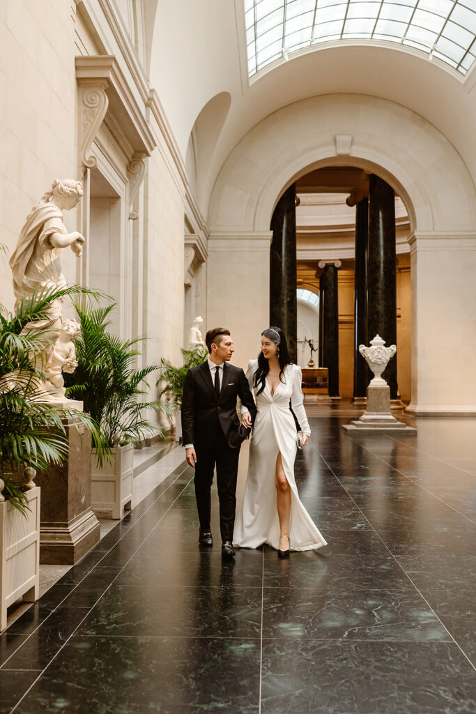 the wedding couple walking through the National Gallery of Art during their Spanish Steps elopement day