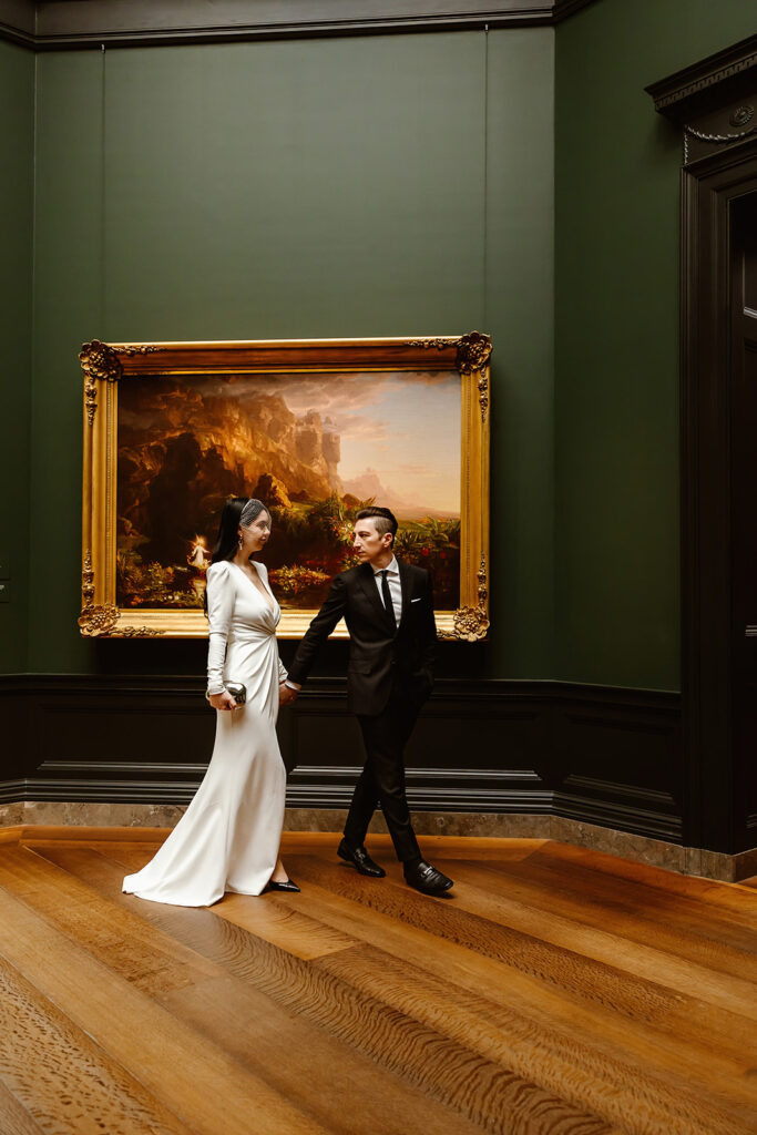 the wedding couple walking together through the National Gallery of Art