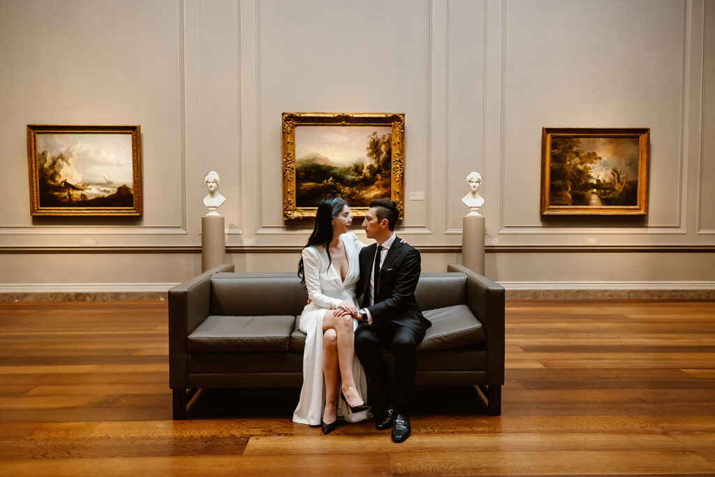 the wedding couple sitting on the couch during their elopement in Washington DC at the National Gallery of Art