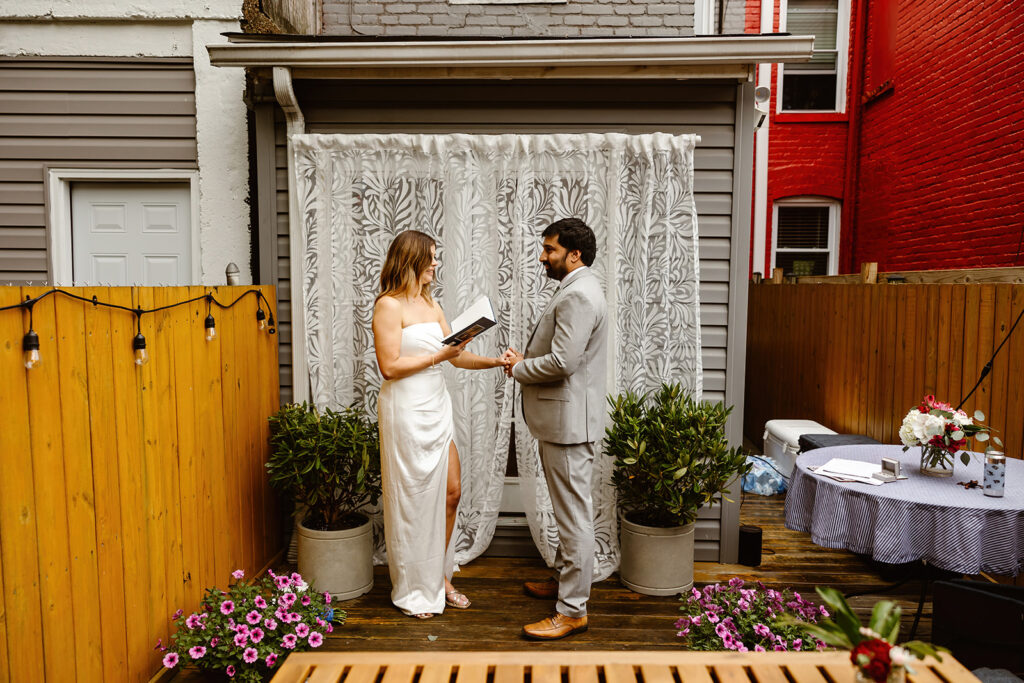 the elopement couple saying their wedding vows during their backyard ceremony