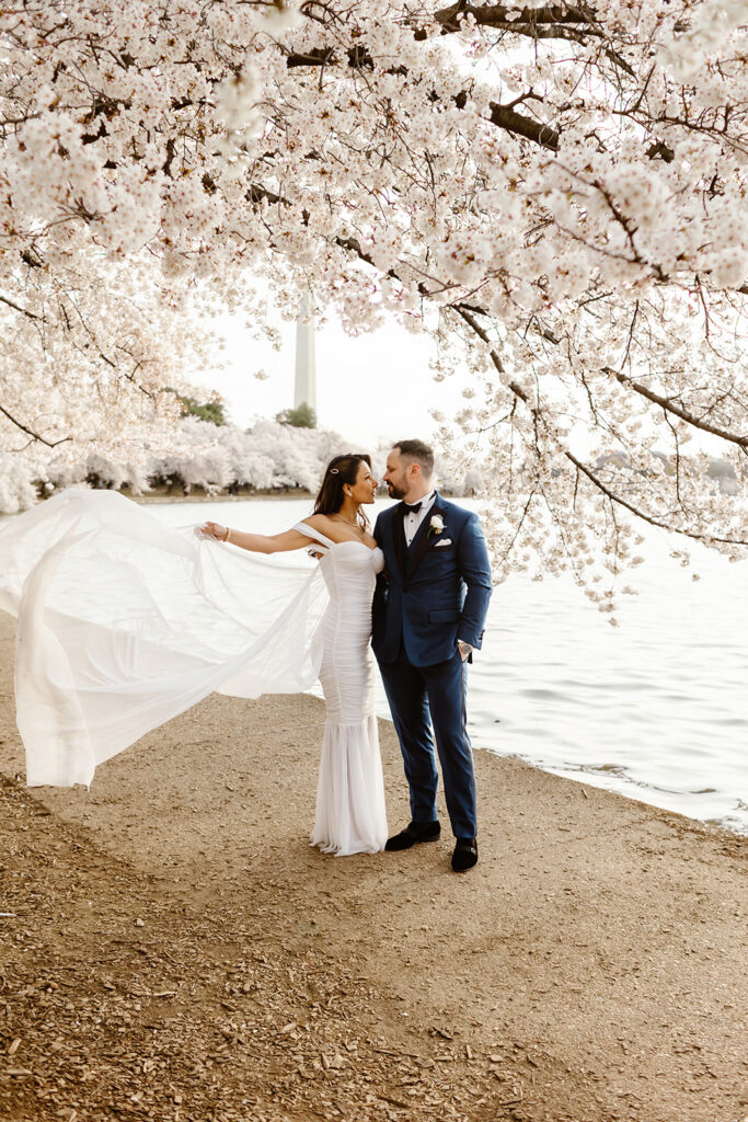 bride and groom surrounded by cherry blossoms during their dc elopement