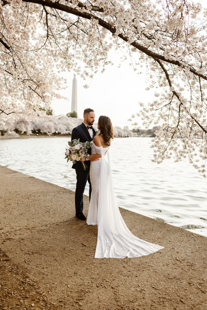 bride and groom surrounded by cherry blossoms during their dc elopement