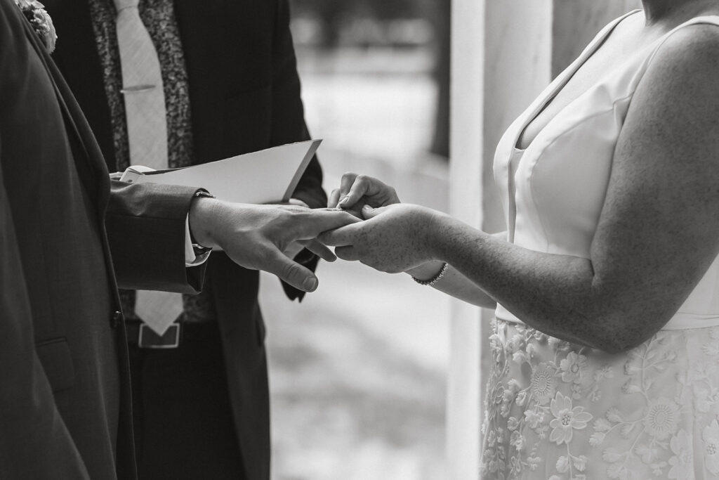 the wedding couple placing rings on their fingers