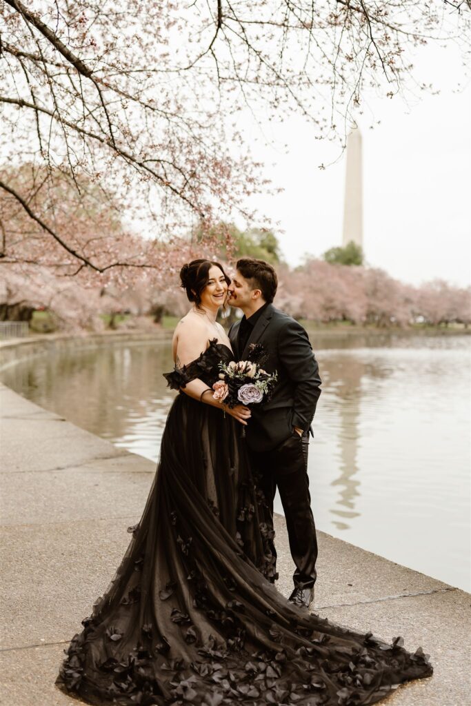 bride and groom surrounded by cherry blossoms during their dc elopement