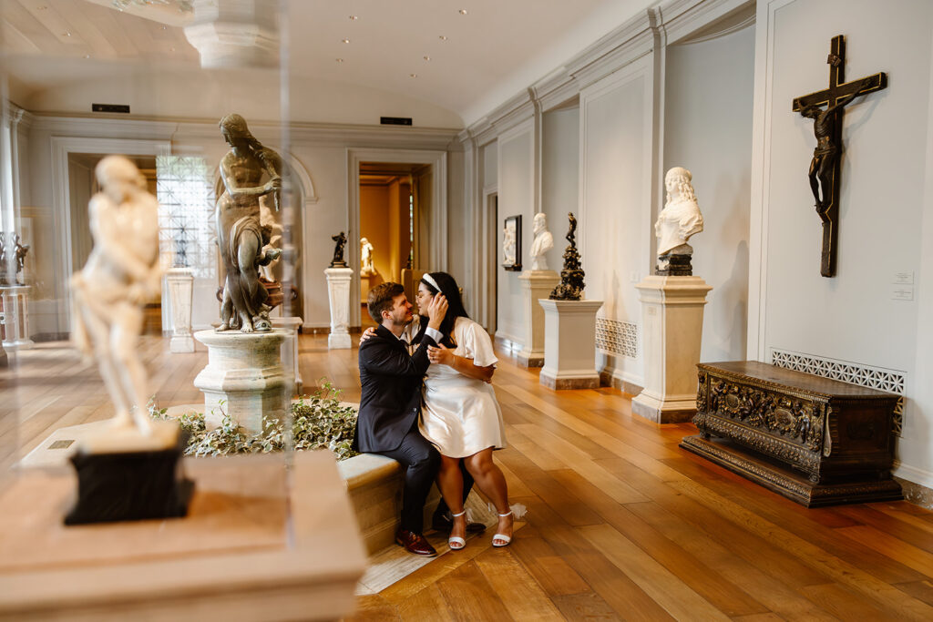 the wedding couple posing by the statues for wedding photos