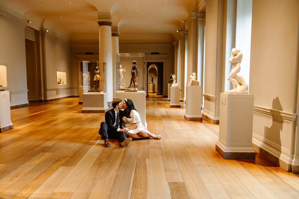 the elopement couple sitting near the statues at the National Gallery of Art