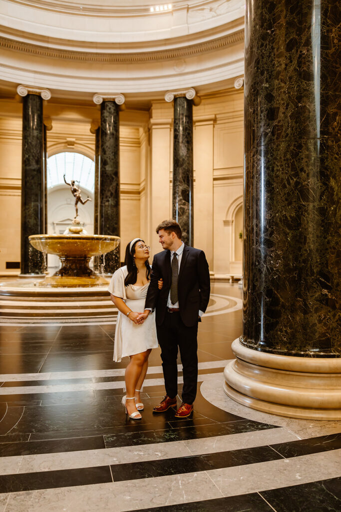 the wedding couple walking though the art museum together