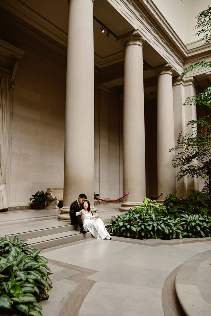 the wedding couple sitting on the ground for elopement photos