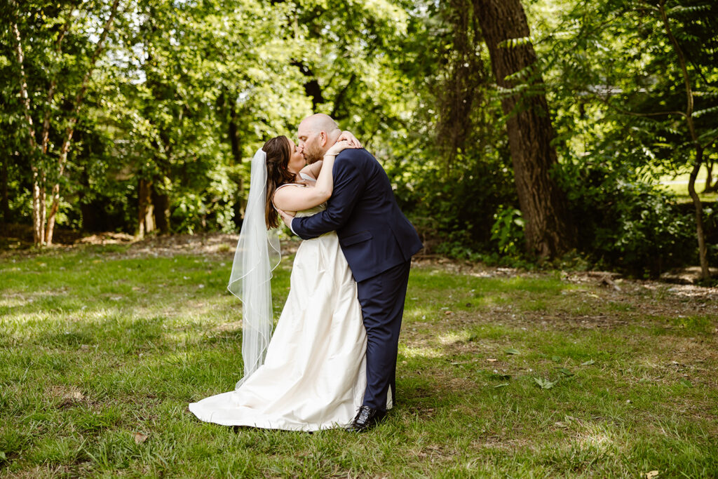 the wedding couple kissing in the outside of their wedding venue in Northern Virginia