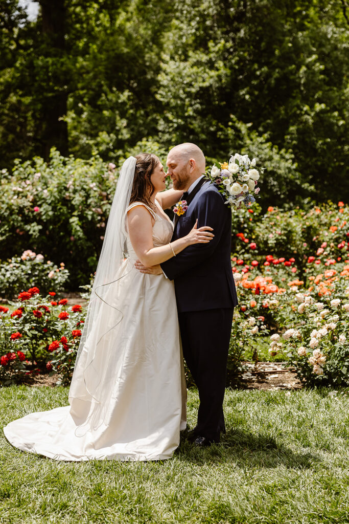 the wedding couple kissing in the rose garden