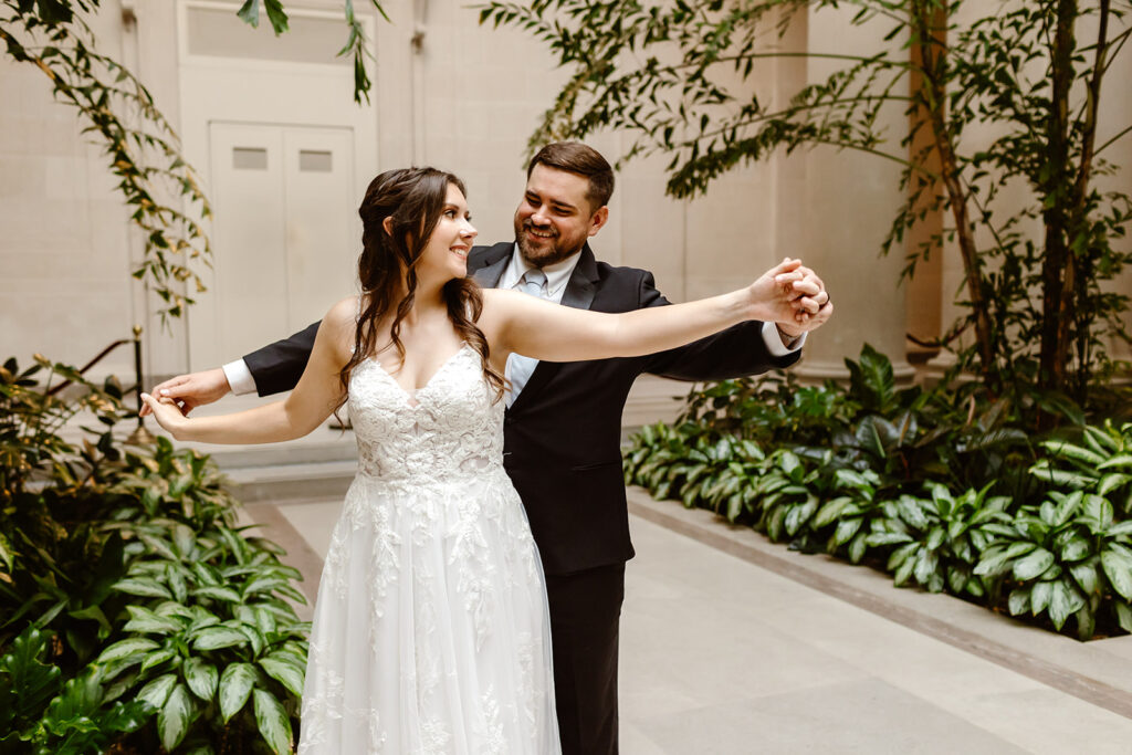 the wedding couple doing the airplane pose in the National Gallery of Art