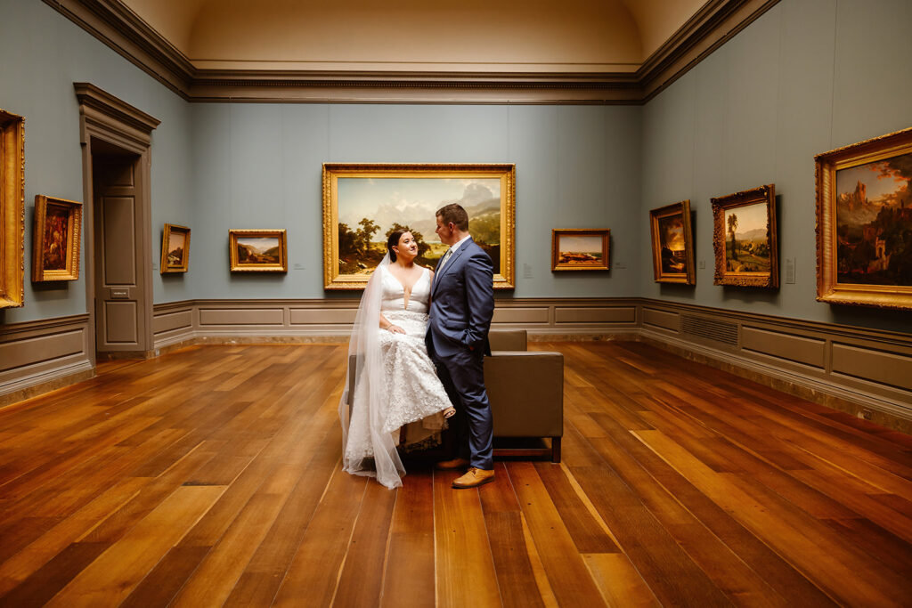 the wedding couple sitting in the art museum