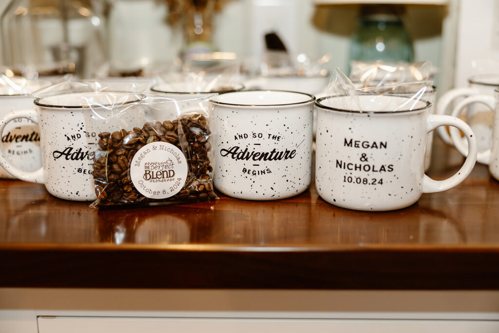 A photo of custom mugs with the wedding couple's names and wedding date and coffee beans as a wedding gift.